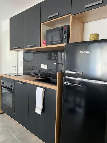 une cuisine avec un réfrigérateur noir et une cuisinière dans l'établissement Appartement de la plage, à Solaro