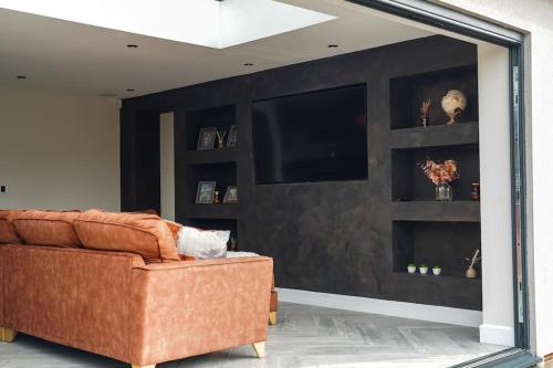 a living room with a couch and a flat screen tv at Modern&Luxury House Near City Centre in York