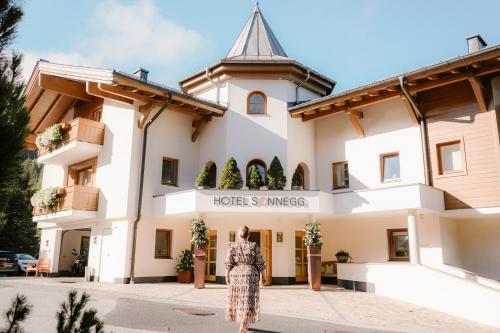 a woman standing in front of a hotel at Hotel Sonnegg in Saalbach Hinterglemm