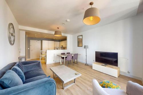 a living room with a blue couch and a table at 1Bed Flat with city views - 1min walk to tube station in London