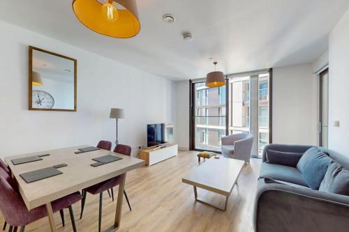 a living room with a blue couch and a table at 1Bed Flat with city views - 1min walk to tube station in London