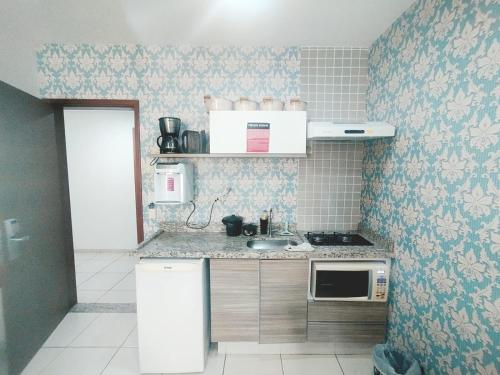 a small kitchen with a sink and a microwave at Riviera Apto 443 in Caldas Novas