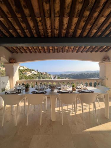 une table et des chaises sur une terrasse avec vue dans l'établissement Villa provençale Magnifique vue Golfe de St Tropez, à Roquebrune-sur Argens