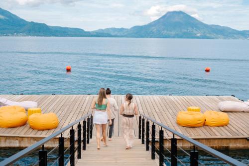 two girls walking on a dock with orange pumpkins at Hotel Casa Palopo in Santa Catarina Palopó