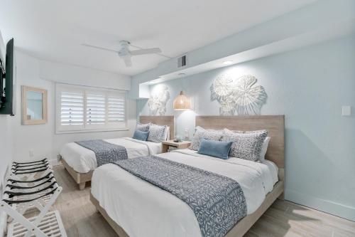 two beds in a bedroom with blue and white at Modern Oceanfront 1 Bedroom Condo, Prime Location, Stunning Views at Beach Cove Resort in Myrtle Beach