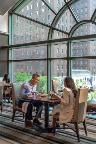 a man and woman sitting at a table in a restaurant at Omni Chicago Hotel in Chicago