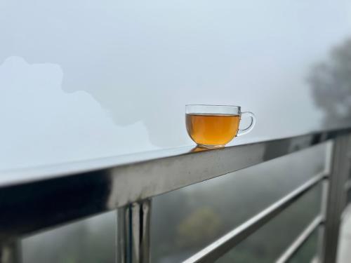 a cup of tea sitting on a railing at Tourbix Mirik in Mirik