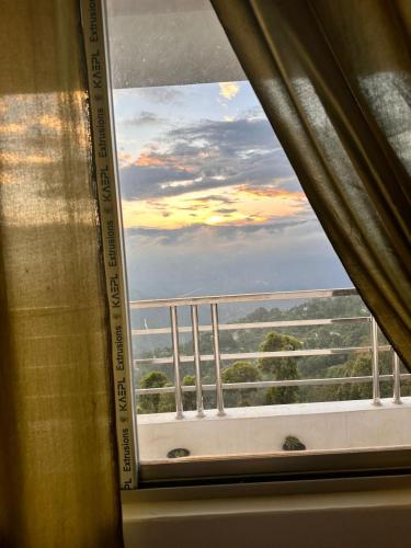 a window with a view of a balcony at Tourbix Mirik in Mirik