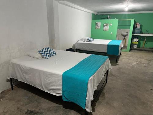 バイーア・ソラノにあるApartaloft en bahia solanoの緑と白の部屋のベッド2台