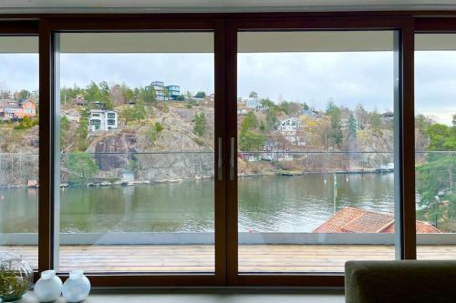 a view of a lake from a window at Exklusiv villa med sjöutsikt och egen brygga in Nacka
