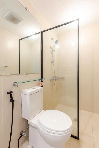 a bathroom with a white toilet and a shower at The Patio at Monaco Tower in Lagundi