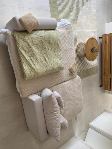 Un baño con una silla blanca con almohada. en Green Pepper Apartments, en Freudenstadt