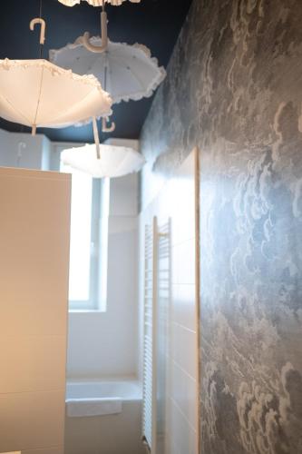 une chambre avec deux lampes et un mur recouvert de nuages. dans l'établissement Le Dada 6 personnes hypercentre Epernay, à Épernay