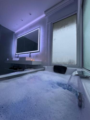 a room with a bath tub with a tv and a television at Serena Boutique Potrero Garay in Potrero de Garay
