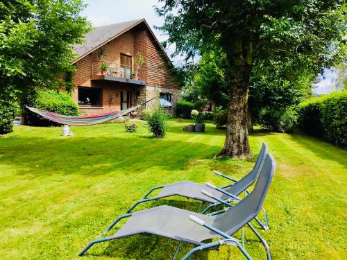 two lawn chairs and a hammock in a yard at Les Églantines in Marche-en-Famenne