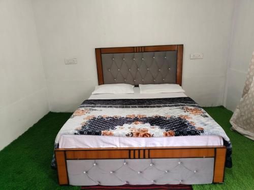 a large bed in a room with green grass at Pahadi Villa by StayApart in Sari