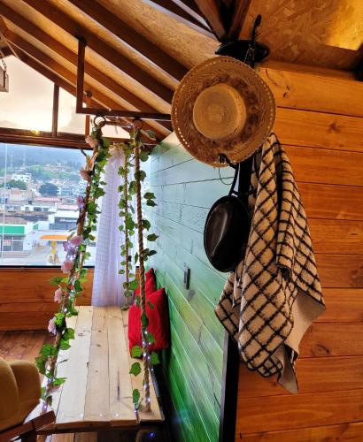 a room with a wooden wall with a table and plants at Cabaña Flores in Sogamoso