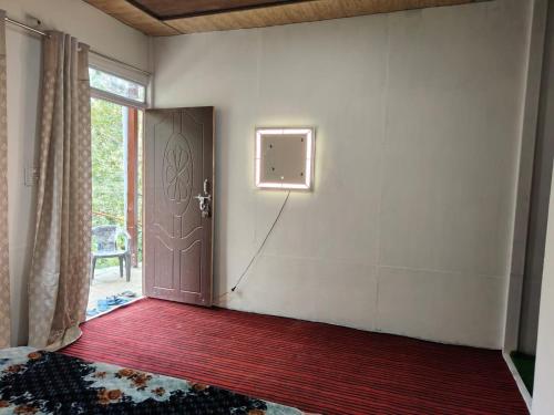 an empty room with a door and a window at Pahadi Villa by StayApart in Sari