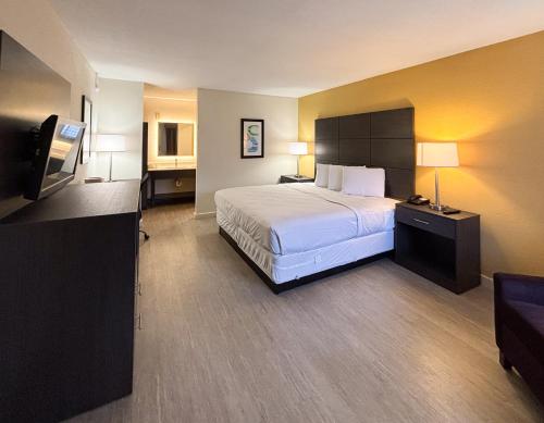 a hotel room with a bed and a flat screen tv at Motel 6 Charlotte, NC Northlake in Charlotte