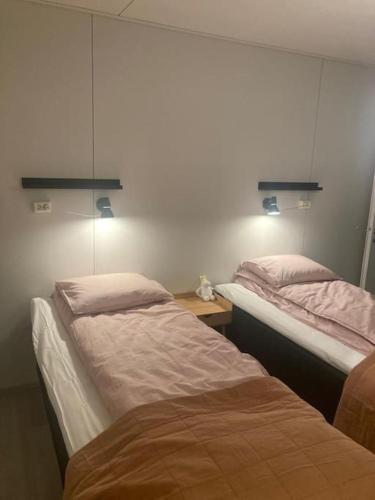 two beds in a room with lights on the wall at Paritalon huoneisto in Raahe