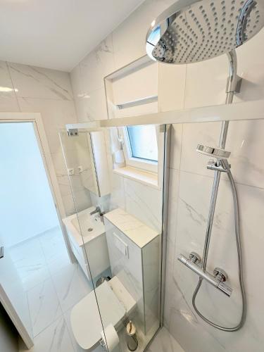 a white bathroom with a shower and a toilet at Beautiful new PalmTree Apartments in Vir