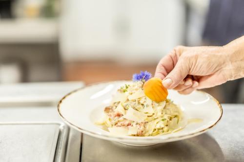 a person is holding a plate of food at Hotel Löwen in Lingenau