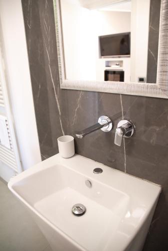 a white sink in a bathroom under a mirror at Hotel Ristorante Europa in Venticano
