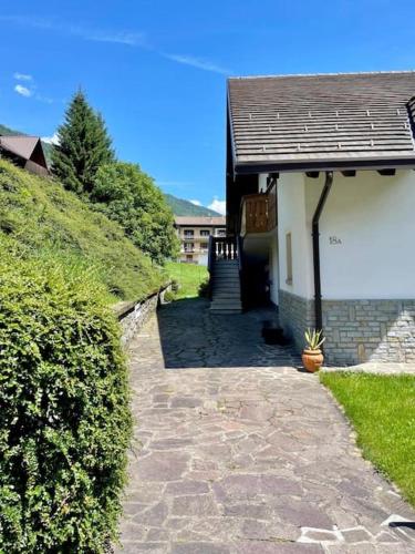 a house with a stone walkway next to a building at Villetta Gaia in Vezza dʼOglio