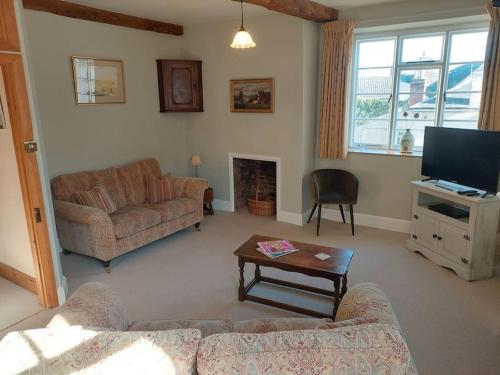 Una sala de estar con un sofá y un televisor. en Ross on Wye The Old Wool Merchants House, en Ross-on-Wye