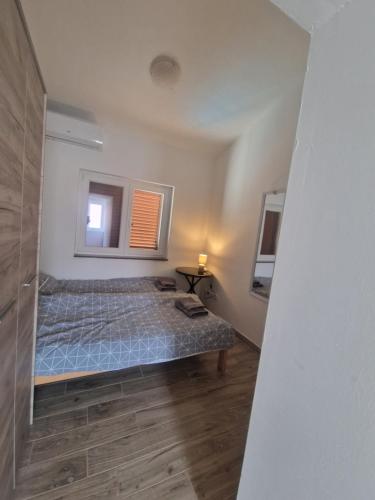 a small bedroom with a bed and a window at Apartmani Carla in Medulin