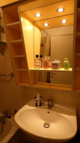 une salle de bain avec un lavabo et un miroir dans l'établissement Superbe T2 avec coin montagne à 2 pas des pistes et des sentiers de randonnée, à Briançon