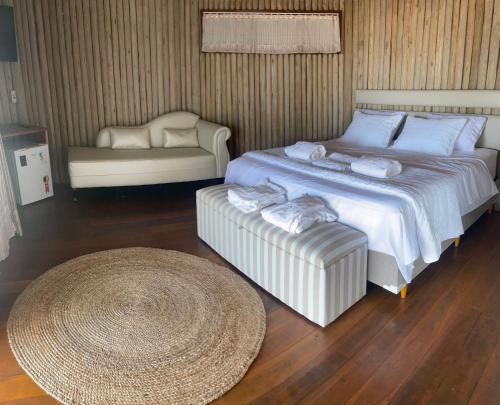 a bedroom with a large bed and a couch at Positano Village in Canoa Quebrada