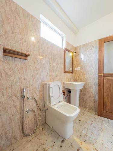 a bathroom with a toilet and a sink at Eden Sea View in Talpe