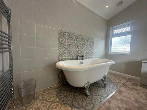 a white bath tub in a bathroom with a window at WH - Smugglers Lodge in Aberaeron