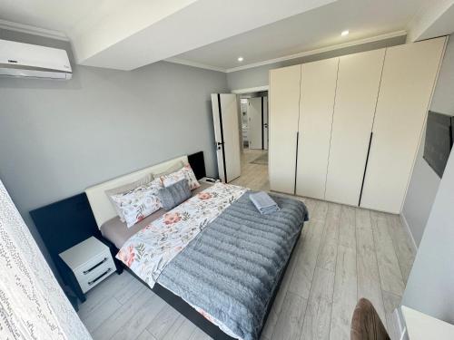a bedroom with a bed and white cabinets at Near Airport Cozy Apartment in Codru