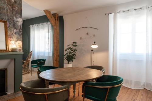 une salle à manger avec une table en bois et des chaises vertes dans l'établissement Le Leon Bourgeois 6 personnes hypercentre Epernay, à Épernay