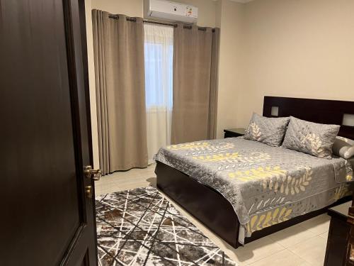 a bedroom with a bed and a window at Elite House الصفوة للشقق الفندقية in 6th Of October