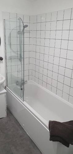 a white bathroom with a tub with a glass shower at Sunrise Central in Bexhill