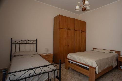 a bedroom with two beds and a wooden cabinet at Villa Bianca Apartment in Loreto
