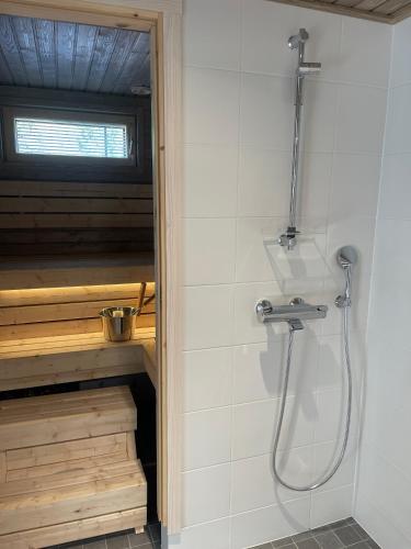 a shower in a bathroom with a sink and a shower at Miilu Resort in Ylläsjärvi