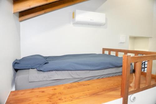 a bed in a small room with a ladder at Blue Paradise House Roatan in Roatan