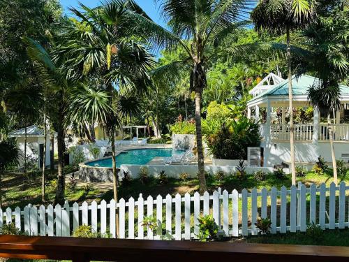 a white fence in front of a house with a pool at Blue Paradise House Roatan in Roatan
