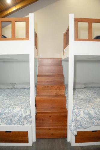 a room with two bunk beds and a staircase at Blue Paradise House Roatan in Roatan