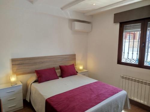 a bedroom with a large bed with red pillows at Villa Pablo, Despeñaperros in Santa Elena