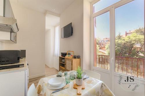 une cuisine avec une table et une grande fenêtre dans l'établissement Le Paisible - Proximité métro A, à Villeurbanne