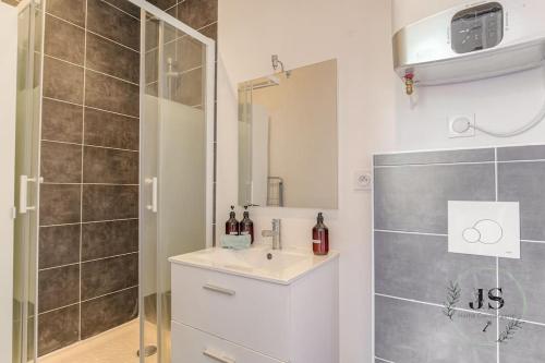 une salle de bain avec une douche, un lavabo et un miroir dans l'établissement Le Paisible - Proximité métro A, à Villeurbanne