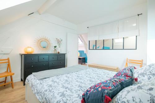 une chambre blanche avec un lit et une commode dans l'établissement Les toits de Fontainebleau, à Fontainebleau