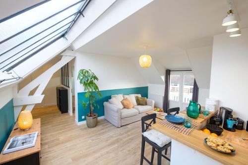 un salon avec un canapé et une table dans l'établissement Les toits de Fontainebleau, à Fontainebleau