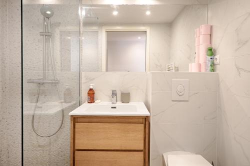 une salle de bain blanche avec un lavabo et une douche dans l'établissement Servandoni - Heart of Saint Germain des Prés - Best location, à Paris