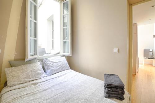 - une chambre avec un lit et 2 fenêtres dans l'établissement Servandoni - Heart of Saint Germain des Prés - Best location, à Paris